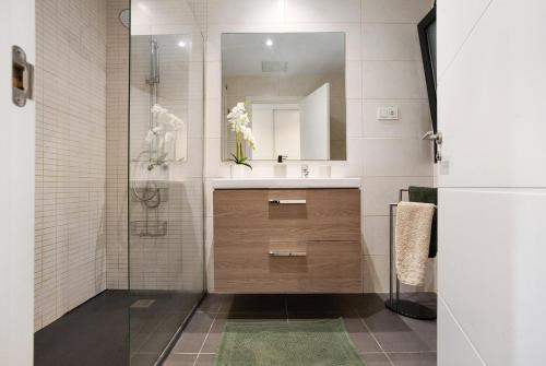 a bathroom with a sink and a shower with a mirror at The Garden Secret in Villaverde