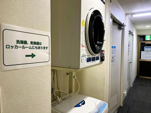a washing machine in a hospital room with a sign at IshiuchiBASE in Minami Uonuma