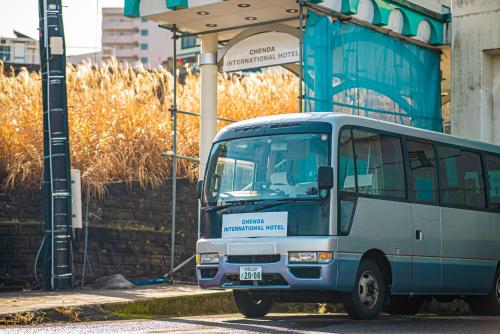 um autocarro azul estacionado em frente a um edifício em CHENDA INTERNATIONAL HOTEL em Minami Uonuma