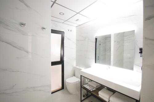 a white bathroom with a sink and a mirror at Hotel BH San Francisco Alicante in Alicante
