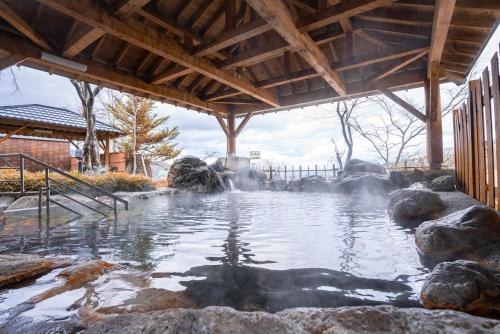 uma piscina de água com uma fonte termal num jardim em CHENDA INTERNATIONAL HOTEL em Minami Uonuma