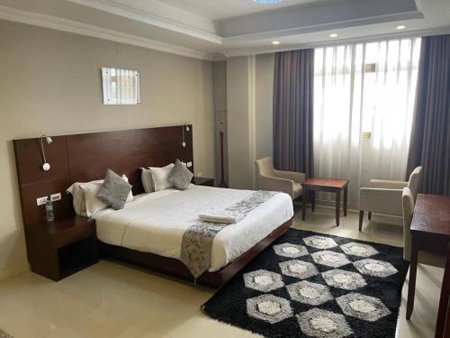 una camera d'albergo con un grande letto e un tavolo di Geza Apartment Hotel ad Addis Abeba