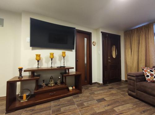 a living room with a couch and a flat screen tv at Rooftop "Montalvo" in Baños
