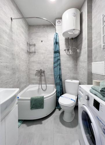 a bathroom with a tub and a toilet and a sink at Радужная студия Вокзал Харьков-Пассажирский in Kharkiv