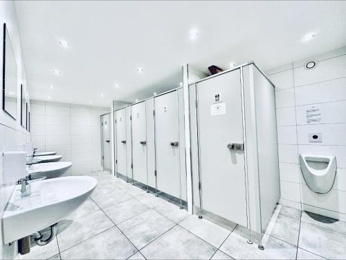 a bathroom with a sink and a toilet and stalls at Monteurzimmer ZIMMERzuVERMIETEN Oensingen in Oensingen