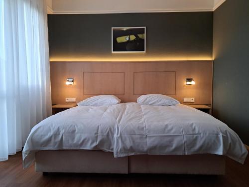 a bedroom with a large bed with two pillows at Hotel Union in Offenburg