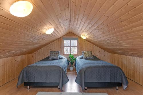 two beds in a room with a roof at Summer House with Stunning Mountain Views in Úthlid