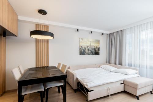 - une chambre avec un lit, une table et un bureau dans l'établissement Bronowice Cosy Apartment, à Cracovie