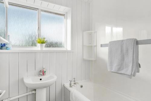 a white bathroom with a sink and a toilet and a window at Birmingham NEC Work stays in Birmingham