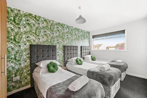 Duas camas num quarto com papel de parede verde em Birmingham NEC Work stays em Birmingham
