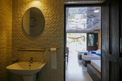 - Baño con lavabo, espejo y 2 camas en Arugamabay Surf Resort, en Arugam Bay