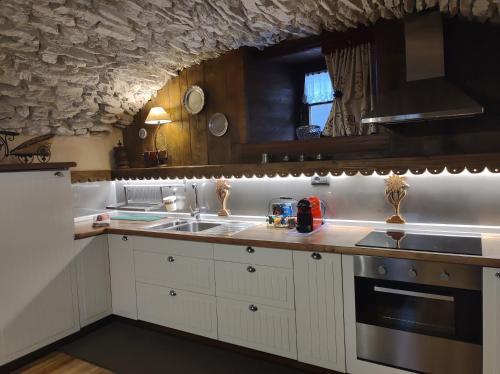 uma cozinha com um lavatório e um fogão forno superior em Le Petit Château de Vetan CIR 0023 em Saint-Pierre