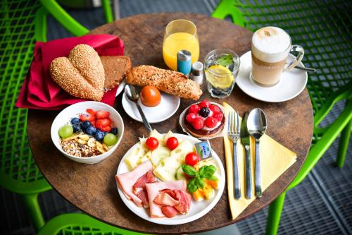 a table with plates of food and a cup of coffee at Stanys - Das Apartmenthotel in Vienna