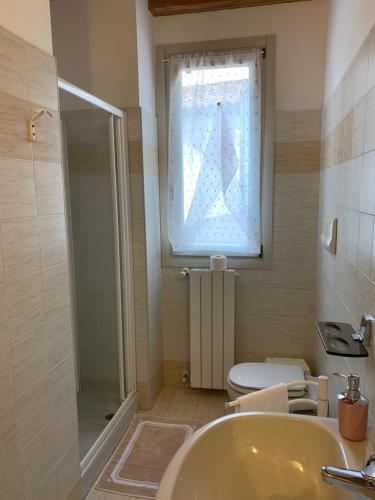 a bathroom with a sink and a toilet and a window at Apartment Orio 2 in Orio al Serio