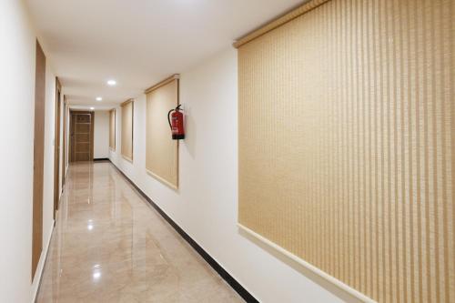 a hallway with white walls and a wall with a wall at V V Grand in Chennai