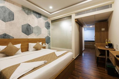 a bedroom with a bed and a desk in a room at V V Grand in Chennai