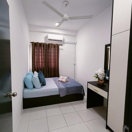Un dormitorio con una cama con almohadas azules y una ventana en KITA IMPIAN B-20-07, en Kampung Dengkil