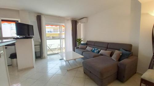 un salon avec un canapé et une télévision dans l'établissement Le Fragonard, à Cannes