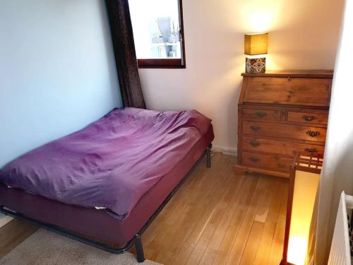 a small bedroom with a bed and a dresser at 70 m² près des bateaux - Paris by the canal in Paris