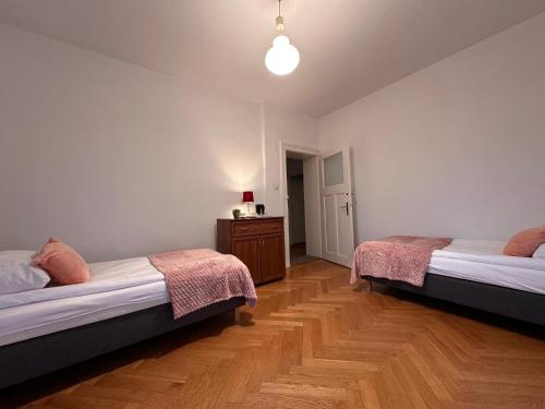 a bedroom with two beds and a wooden floor at Willa pod Bukami in Polanica-Zdrój