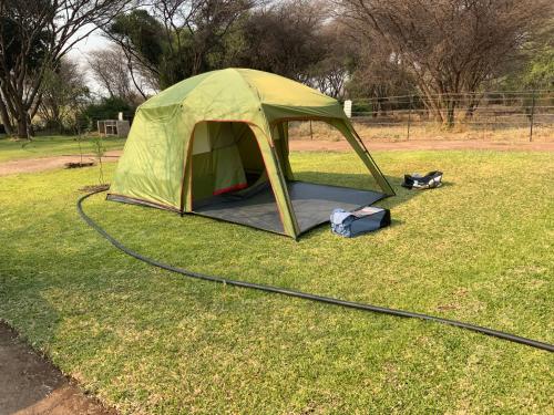 a green tent on the grass in a field at Lorato Camping in Muchenje