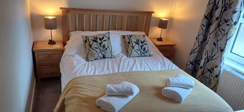 - une chambre avec un lit et des serviettes dans l'établissement Herriot's Nook, à Thirsk