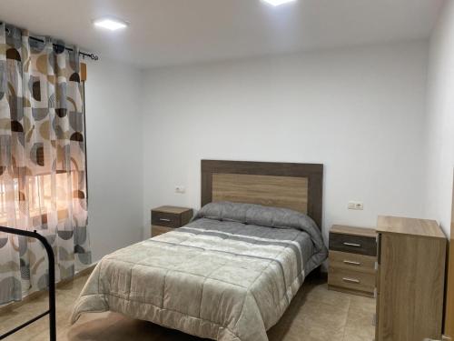 1 dormitorio con 1 cama y 2 mesitas de noche en Apartamento Ballesta Jubilar, en Caravaca de la Cruz