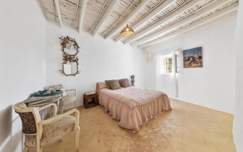 Un dormitorio con una cama y una mesa y sillas. en Cortijo El Albaricoque De La Sierra - Finca de 75 Hectáreas !, en Níjar
