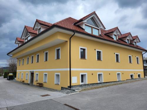 a large yellow building with a red roof at Stara Pošta Apartment 1 in Grosuplje
