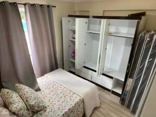 um quarto com uma cama, uma prateleira e um espelho em Centro de poços de caldas em Poços de Caldas