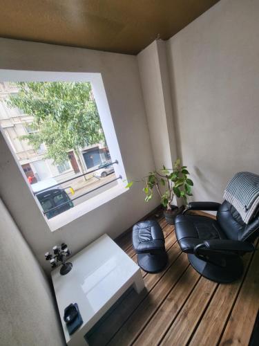 a room with a chair and a table and a window at Cosy in Antwerp