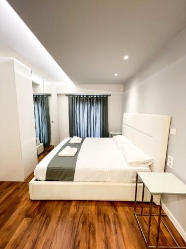 una camera da letto con un grande letto bianco e pavimenti in legno di Botafoch Luxury Room a Ibiza Città