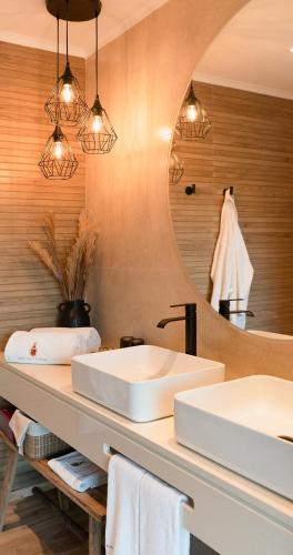 a bathroom with two sinks and a mirror at Hotel Real d Obidos in Óbidos