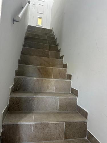 a stairway with a cement staircase with a white door at Zamárdi Parti Apartman in Zamárdi