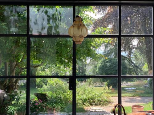 uma janela aberta com vista para um pátio em 'Le Petit Clos Suites'- Charming Garden Villa on Leman Lake em Nyon