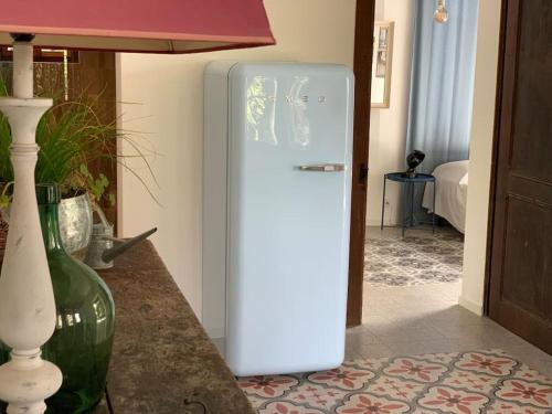 a white refrigerator in a room with a table at 'Le Petit Clos Suites'- Charming Garden Villa on Leman Lake in Nyon