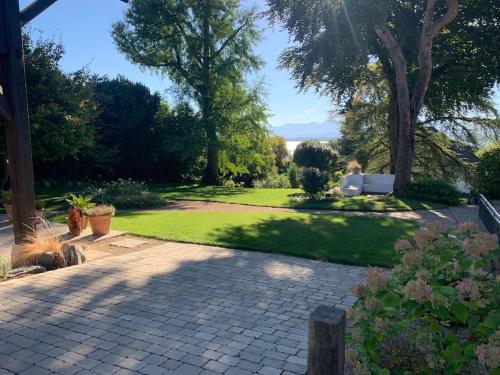 a garden with a brick walkway and trees and grass at 'Le Petit Clos Suites'- Charming Getaway on Leman Lake in Nyon