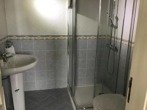 a bathroom with a shower and a toilet and a sink at The Garden Room in Bombarral