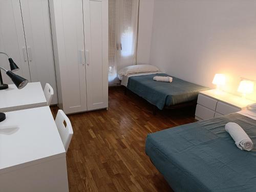 Habitación pequeña con 2 camas y escritorio. en Sant Jordi Pisos - Consell de Cent en Barcelona