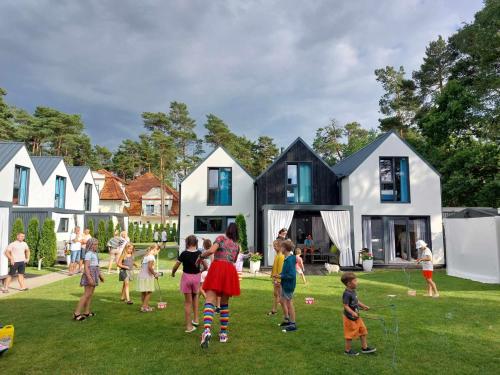 a group of children playing in the yard of a house at Villa6 I Domki Pobierowo in Pobierowo