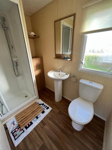 a small bathroom with a toilet and a sink at E4A, Three bedroom caravan - California Cliffs, Parkdean Resort, Scratby - Sleeps 8, bed linen and towels included - Pet Friendly - only 300m from the beach! in Great Yarmouth