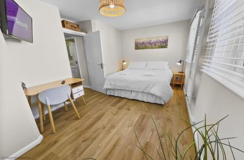 a bedroom with a bed and a desk and a desk at Whitsun 1,5 in Gosport