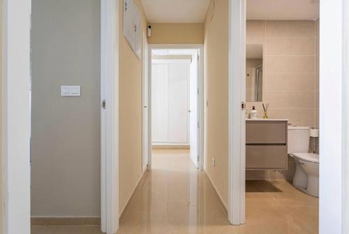 een hal van een badkamer met een toilet en een wastafel bij CASA AMANECER 1ªLinea de Playa Familiar in Castellón de la Plana