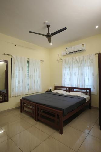 a bedroom with a bed and a ceiling fan at Cliff & Coral in Varkala