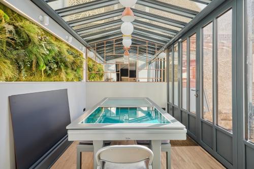 - une piscine dans une pièce avec une table et des chaises dans l'établissement Morny Haven - A 500m de la plage, à Deauville