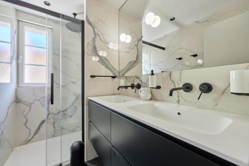 une salle de bain blanche avec un lavabo et une douche dans l'établissement Morny Haven - A 500m de la plage, à Deauville