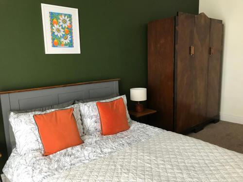 a bedroom with a bed with two orange pillows at Apartment One Hull in Hull