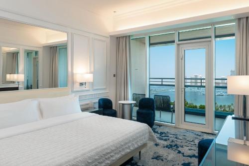 a bedroom with a bed and a large window at Le Meridien Mina Seyahi Beach Resort & Waterpark in Dubai