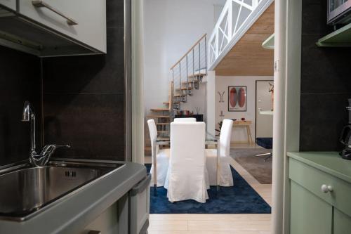 een keuken met een tafel en stoelen en een trap bij Casa Bartolomeo - Loft in Trastevere in Rome