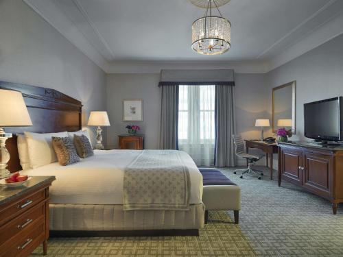 a bedroom with a bed and a desk and a television at Fairmont Copley Plaza in Boston